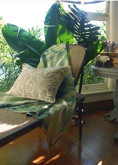 a chair sitting in front of a window next to a table