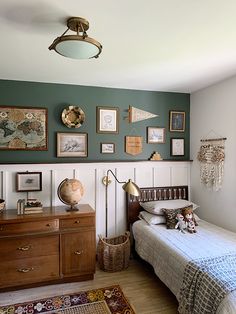 a bed room with a neatly made bed and lots of pictures on the wall above it