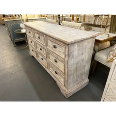 an old white dresser in a store filled with furniture