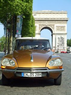 an old car is parked in front of the arc de trioe