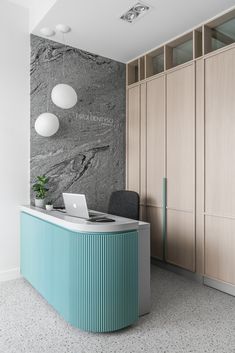 an office with a large marble wall and blue reception table in front of the counter