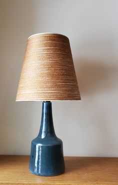 a blue table lamp sitting on top of a wooden table