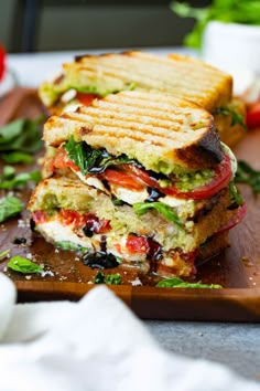 a sandwich cut in half sitting on top of a cutting board next to some vegetables