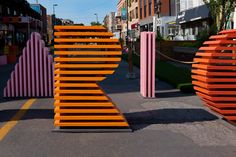 several orange and pink sculptures in the middle of a street