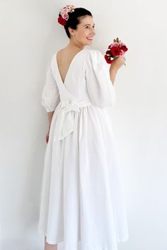 a woman in a white dress holding flowers