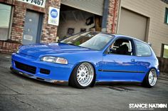 a blue car parked in front of a building