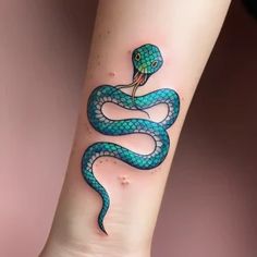 a blue and green snake tattoo on the wrist