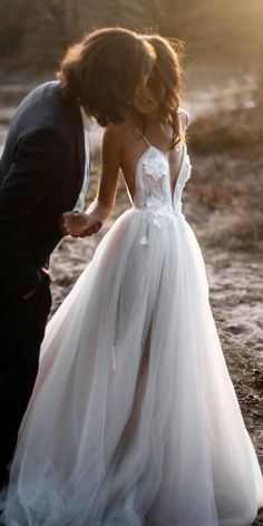 a woman in a wedding dress standing next to a man