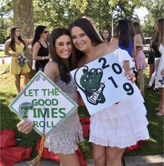 two girls are holding signs and posing for the camera