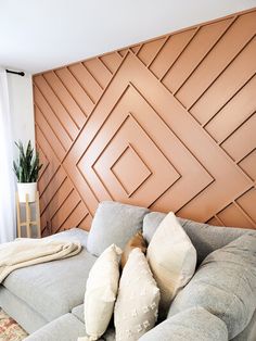 a couch with pillows on it in front of a wood paneled wall