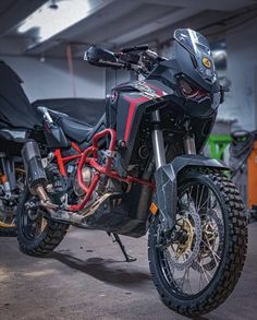 a black and red motorcycle parked in a garage