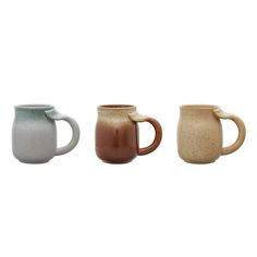 three different colored mugs sitting next to each other