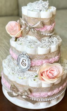 a three tiered diaper cake with pink roses on top