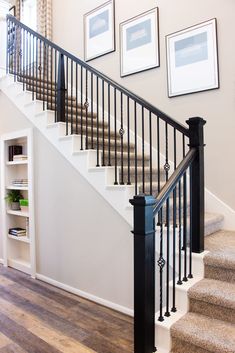 there is a stair case next to the banister in this house with pictures on the wall