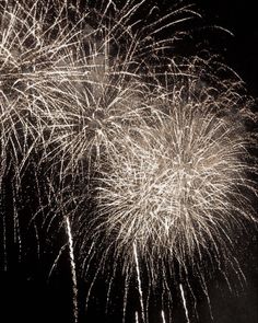 fireworks are lit up in the night sky with black and white lighting on it's sides