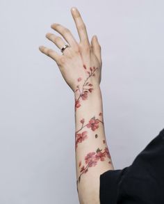 a woman's arm with red flowers on it