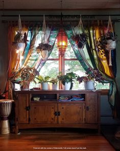 a living room with a large window and plants on the shelf in front of it