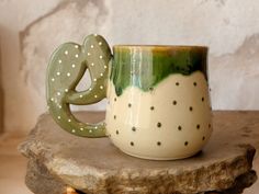 a green and white coffee cup sitting on top of a rock