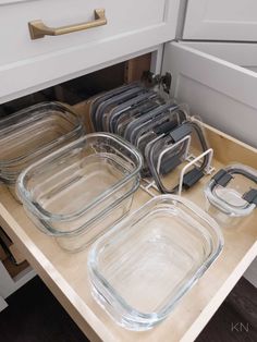 the drawers are filled with clear dishes and lids for baking or other things to cook in