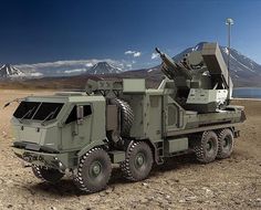 an army truck with a missile on the back parked in front of some snow capped mountains