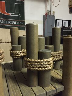 several wooden posts tied up with rope on top of a wood table in a shop