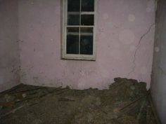 an unfinished room with a window and some wood sticks in the floor next to it