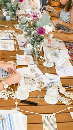 people sitting at a table with vases and papers on it, all covered in thread