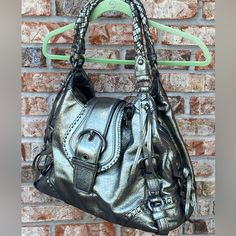 Coach Annie Gunmetal Metallic Leather Shoulder Bag 14236 Hard To Find! This Bag Has Never Been Used. Includes Dust Bag And Hang Tags. Beautiful Braided Leather Handles. Approximate Measurements Are Depth: 6" Height: 12" Width: 17" Strap Drop: 11". Comes From A Smoke Free Home. Thank You! Luxury Silver Metal Bag, Gold Tote Bag With Palladium Hardware, Silver Leather Tote Satchel, Designer Silver Leather Shoulder Bag, Silver Leather Shoulder Satchel, Elegant Hobo Bag With Gunmetal Hardware For Evening, Silver Metal Shoulder Bag For Everyday Use, Luxury Metallic Bag With Metal Hardware, Luxury Silver Shoulder Bag With Gold-tone Hardware