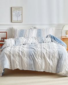 a bed with blue and white comforters in a bedroom