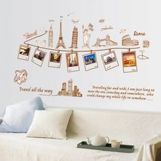 a living room with a white couch and wall decals on the walls that say travel life is easy