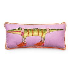 a pink pillow with an image of a dinosaur on the front and orange trimmings