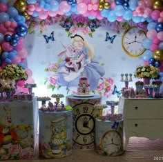 there are many clocks on the table with balloons in the back ground and decorations around it