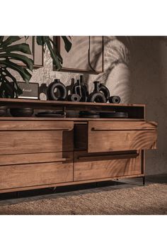 a large wooden dresser with drawers and vases on top