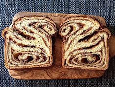 two slices of bread on a cutting board with swirly toppings, sitting on a blue surface