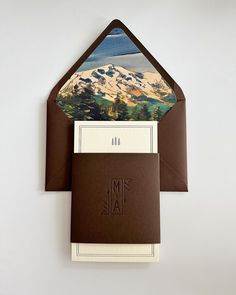 an envelope with a mountain scene on the front and inside is open to reveal a note card