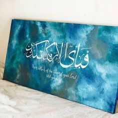 a painting with arabic writing on it sitting on a bed