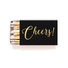 matches with the word cheers written on them in gold foil and black box filled with matches