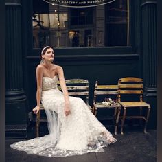 a woman in a wedding dress sitting on a chair