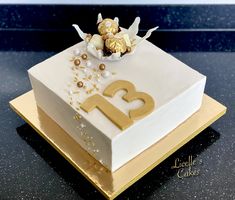 a square cake decorated with gold and white decorations