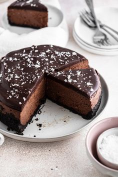 a chocolate cake on a plate with one slice cut out and the other half eaten