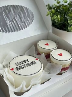 two cakes in a box with the words happy birthday written on them and red hearts