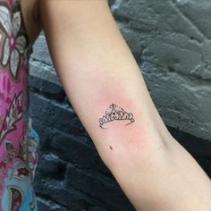 a woman with a tattoo on her arm that has a small crown on the left arm