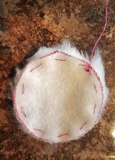 a white piece of fabric with red thread on it sitting on top of a counter