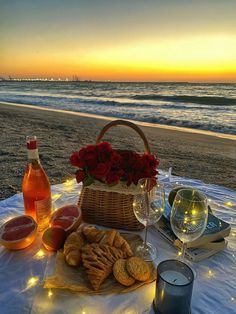 a table on the beach with wine and snacks