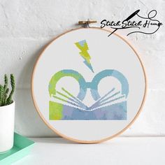 a cross stitch pattern with an image of a book and lightning in the shape of a heart