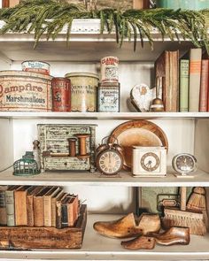 an old fashioned shelf with books, antiques and other items on it's shelves