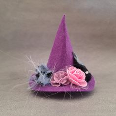 a small purple hat with flowers on the front and one pink flower in the middle