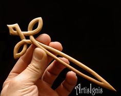 a hand holding a pair of wooden scissors