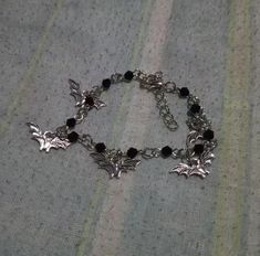 Embrace the dark side with our Gothic Bat Charm Bracelet, a striking accessory for any goth jewelry enthusiast. Featuring a gothic bat design, this bracelet is a statement piece that complements various styles and occasions, from casual wear to black bat dresses. The adjustable length, with a 4.5cm extension chain, ensures a perfect fit for wrists ranging from 17.5cm to 22cm or 20.5cm to 25cm. Crafted with durable materials, this bat mammal-inspired bracelet is built to withstand daily wear. It' Gothic Accessories Aesthetic, Vampiric Jewelry, Goth Jewelry Bracelets, Vampire Goth Accessories, Gothic Accessories Bracelets, Gothic Style Metal Bracelet, Vampire Bracelet, Handmade Silver Gothic Bracelet, Goth Bracelets