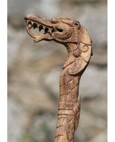 a wooden carving of a dragon head on a stick